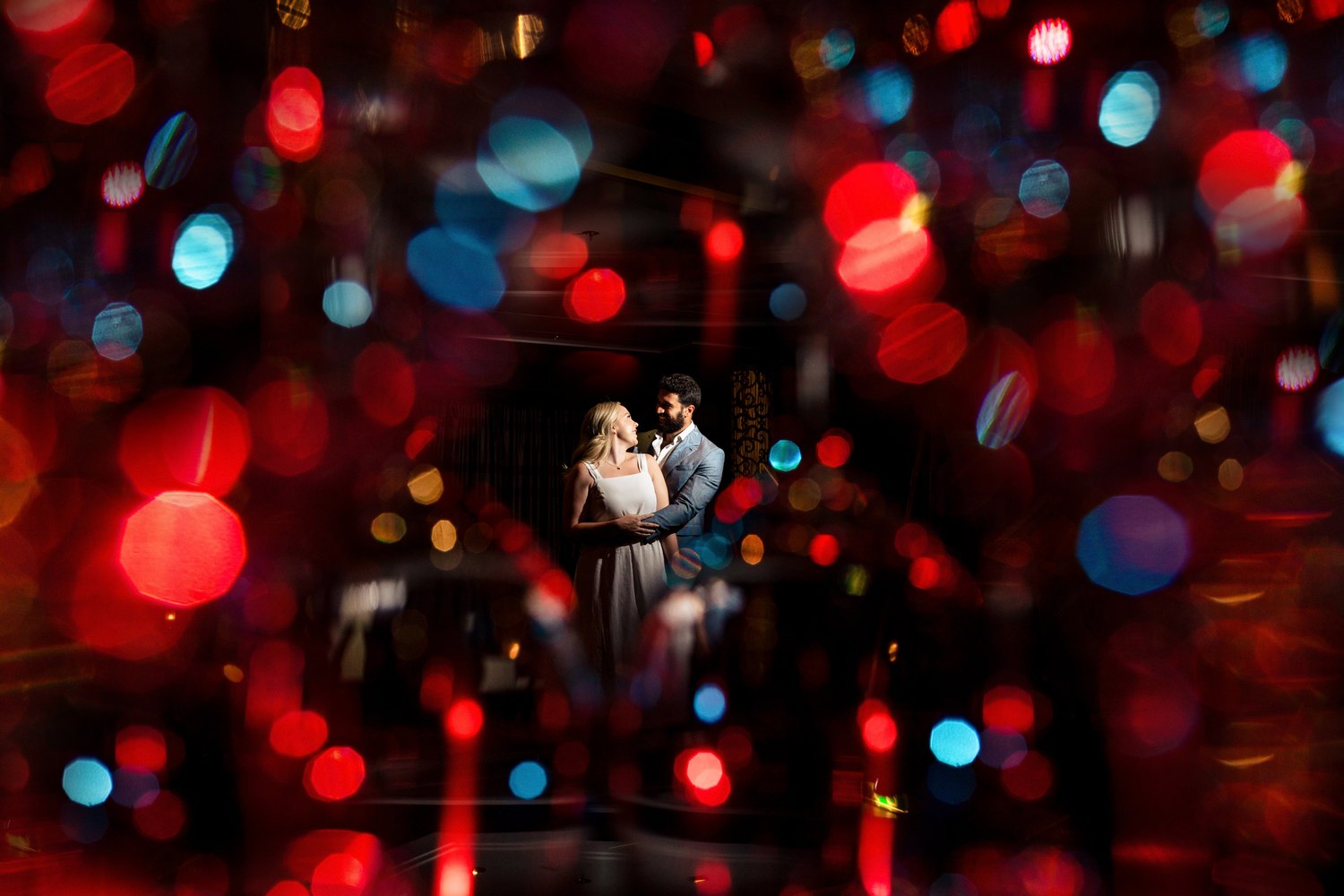 Couple sharing a quiet moment amid bokeh lights at their reception
